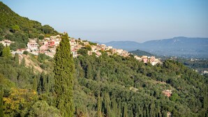 Un village perché sur une colline, avec des bâtiments nichés au milieu des arbres.