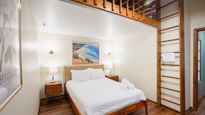 Ein Schlafzimmer mit einem hölzernen Bett, Nachttischen mit Lampen, einem Bild an der Wand und einer Leiter mit Warnschild.