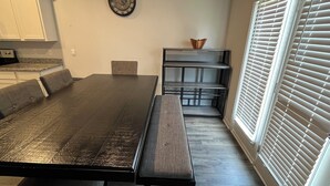 A dining area with a long table, benches, and a clock on the wall. - Masters 2026 Rental Home w/Additional Loft in Grovetown, GA! (Grovetown)