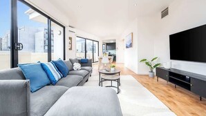 En moderne stue med sofa, sofabord og fjernsyn.