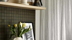 A kitchen with a wooden countertop, a white vase with yellow flowers, a framed black and white photo, and a hanging pot. - Scandinavian Suite, Lap Pool, Big Gym, Melbourne (South Yarra)