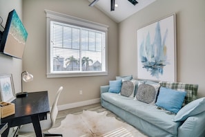 A living room with a light blue sofa, a white rug, and a painting of sailboats. - It's Miller Time (Holmes Beach)