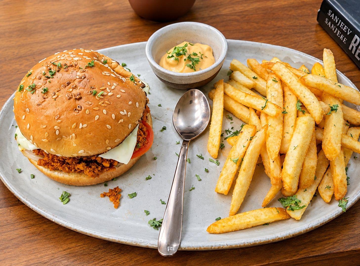 Ein Teller mit einem Burger, Pommes und einer kleinen Soßenportion.