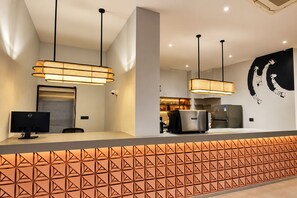 Una cocina moderna con una isla central, iluminación colgante y una gran obra de arte blanco y negro en la pared.