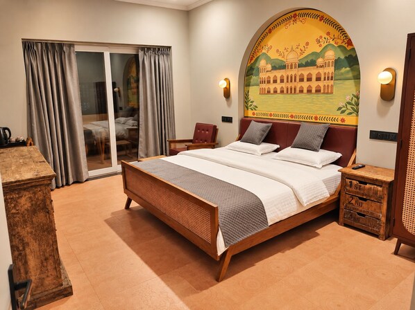 Habitación de hotel con una cama grande, puerta corrediza de vidrio a un balcón y un mural de un edificio en la pared.