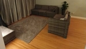 Ett vardagsrum med en hörnsoffa, ett litet soffbord och en matta.