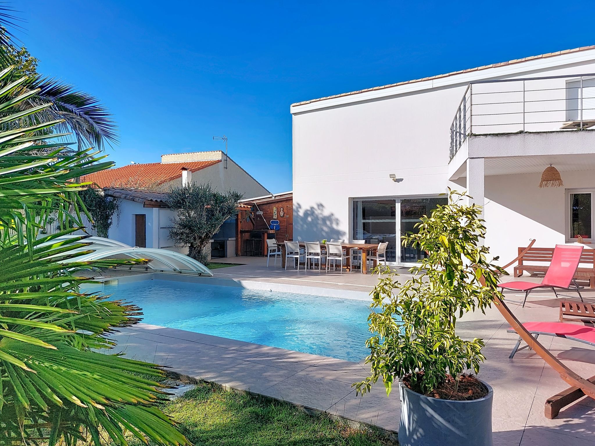 A swimming pool with a waterfall feature, surrounded by a patio area with outdoor furniture.
