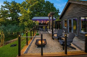 A deck with a fire pit, outdoor seating, and a covered area with string lights. - Maple Lodge - sleeps 2 guests in 1 bedroom (South Duffield)