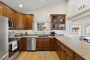 A kitchen with wooden cabinets, stainless steel appliances, a window with a view, and a built-in oven. - EagleVail Home-Golf/Ski -Beaver Creek & Vail (Vail)