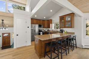 A spacious kitchen with a large island, wooden cabinets, and a high ceiling with exposed beams. - EagleVail Home-Golf/Ski -Beaver Creek & Vail (Vail)