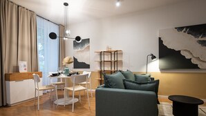 Un salon moderne avec un canapé, une table à manger et des chaises. On y trouve également une bibliothèque et une lampe.