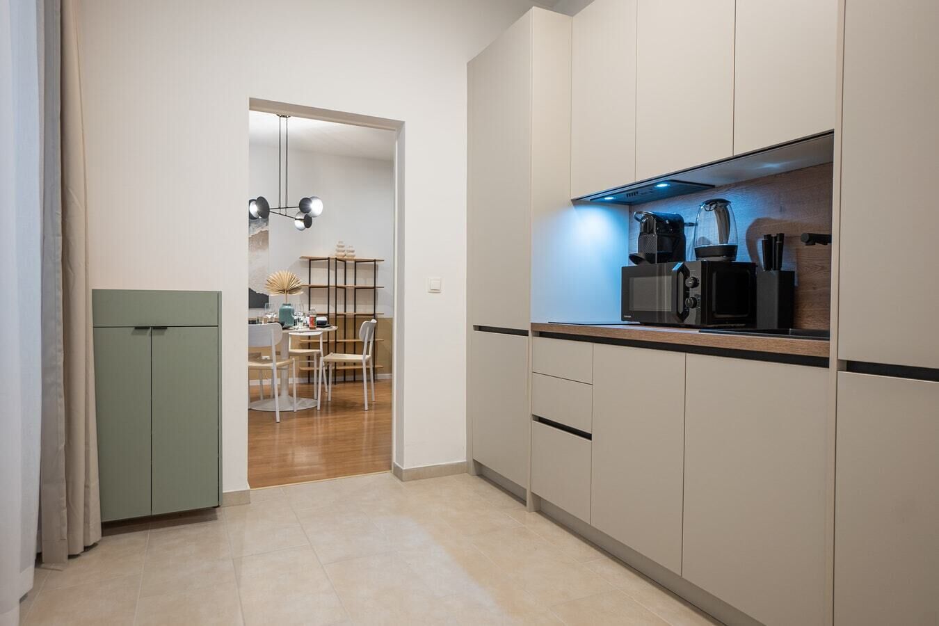 Eine moderne Küche mit Mikrowelle, Kaffeemaschine und einem Essbereich mit Tisch und Stühlen.
