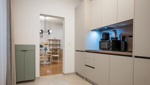 Une cuisine moderne équipée d’un four à micro-ondes, d’une machine à café et d’un coin repas avec une table et des chaises.