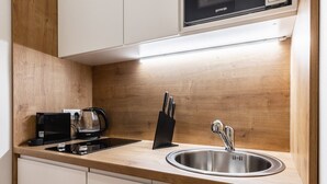 Een moderne keuken met een roestvrijstalen spoelbak, een koffiezetapparaat en een messenblok.
