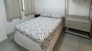 A bedroom with a bed, an air conditioning unit, a window with curtains, and a built-in shelf with storage boxes. - Retreat with a view of Christ the Redeemer, South Zone of Rio de Janeiro (Rio de Janeiro)