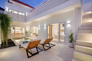 A modern house with a swimming pool, two lounge chairs, and a staircase. - Villa Bora Berawa (Canggu)