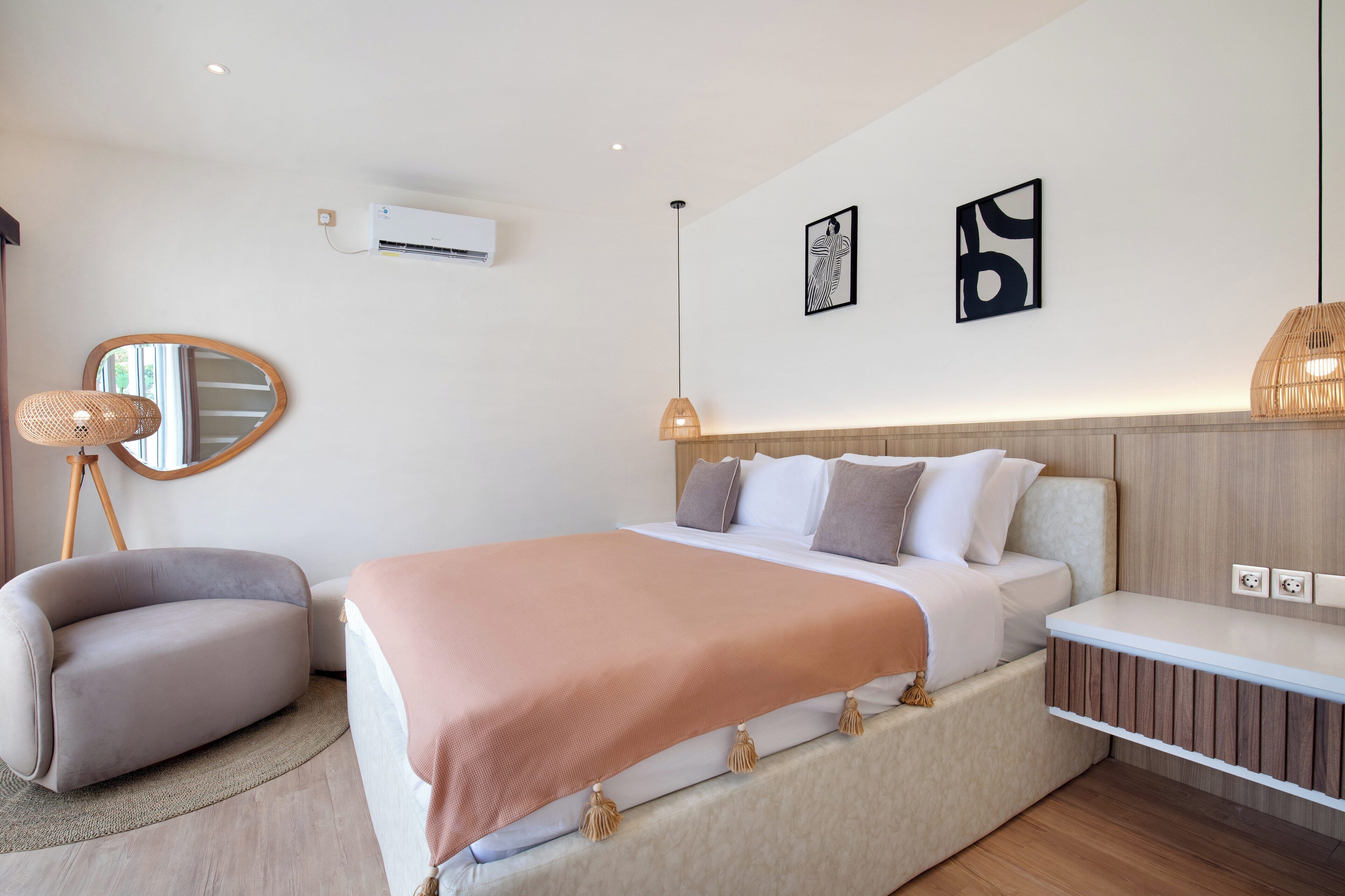 Une chambre à coucher moderne avec un grand lit, un canapé et un miroir.