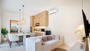 Ein modernes Wohnzimmer mit Sofa, Essbereich und Küche.