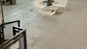 Ein Innenhof mit Sitzgelegenheit, einer Zierpflanze und Lichterketten.