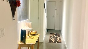 Ein schmaler Flur mit einem Holztisch, einer Lampe und dekorativen Wandleuchten.