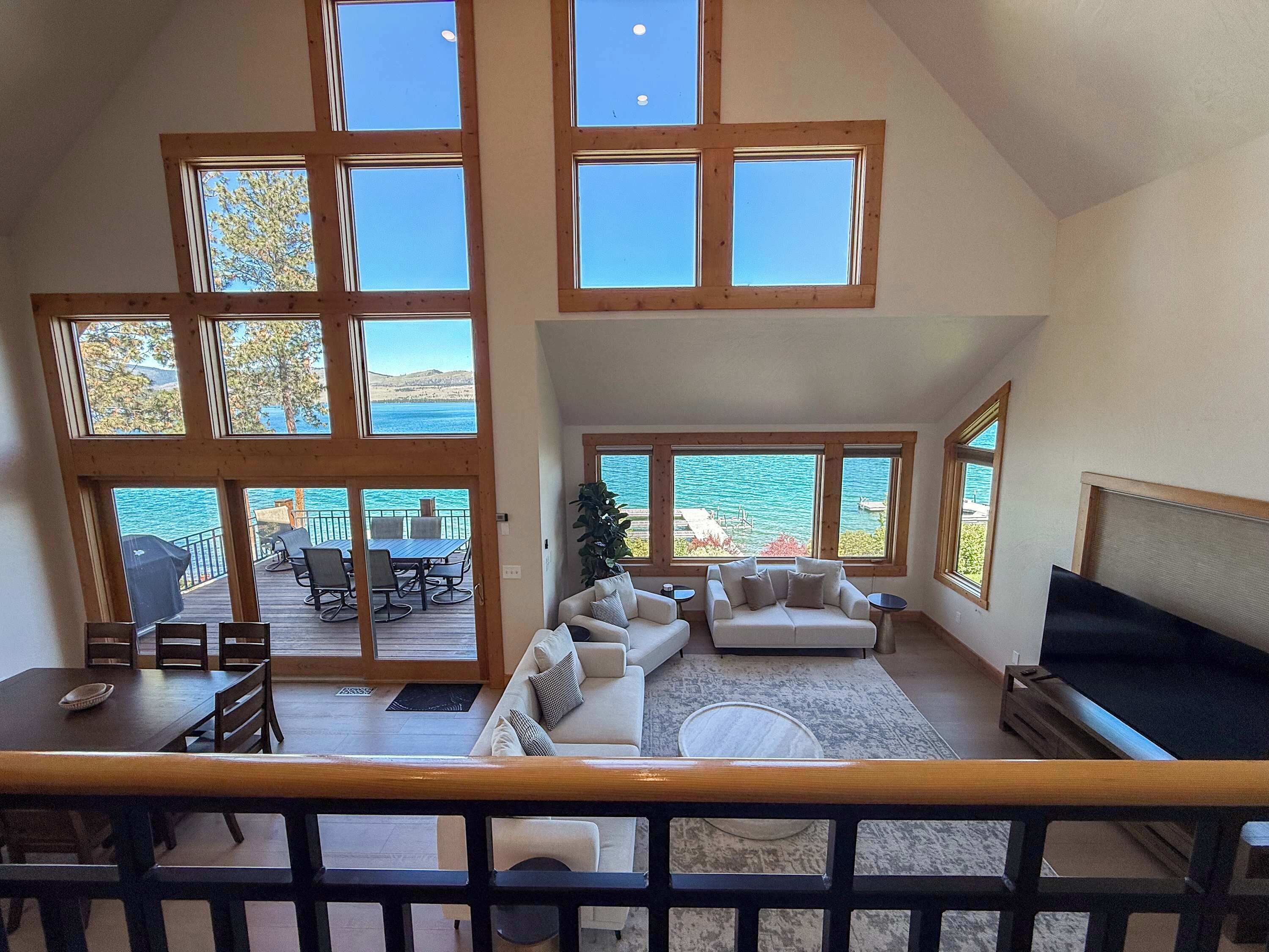 A spacious living area with a large window overlooking a scenic view, a cozy seating area, and a dining space with outdoor furniture.