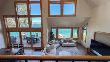 A spacious living area with a large window overlooking a scenic view, a cozy seating area, and a dining space with outdoor furniture.