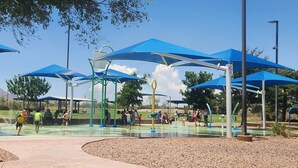 Een waterpark met verschillende speelconstructies en schaduwrijke zones.