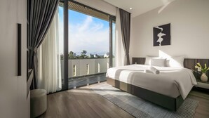 A modern bedroom with a large bed, a view of the city, and a balcony.