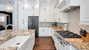 A kitchen with white cabinets, a stainless steel refrigerator, a gas stove, and a granite countertop. - Contour - Priv Pool- Fun Design- Mins 2 everything (Phoenix)