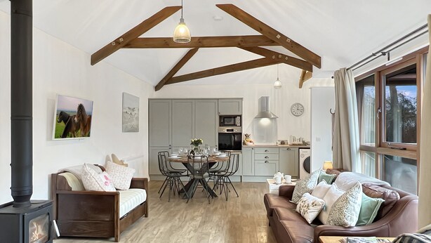 A cozy living room with a fireplace, a dining area, and a kitchen. - Westlands, Brendon Hill on Exmoor (Nr Watchet)