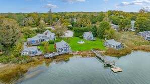A lakeside property with multiple houses, a dock, and a well-maintained lawn.