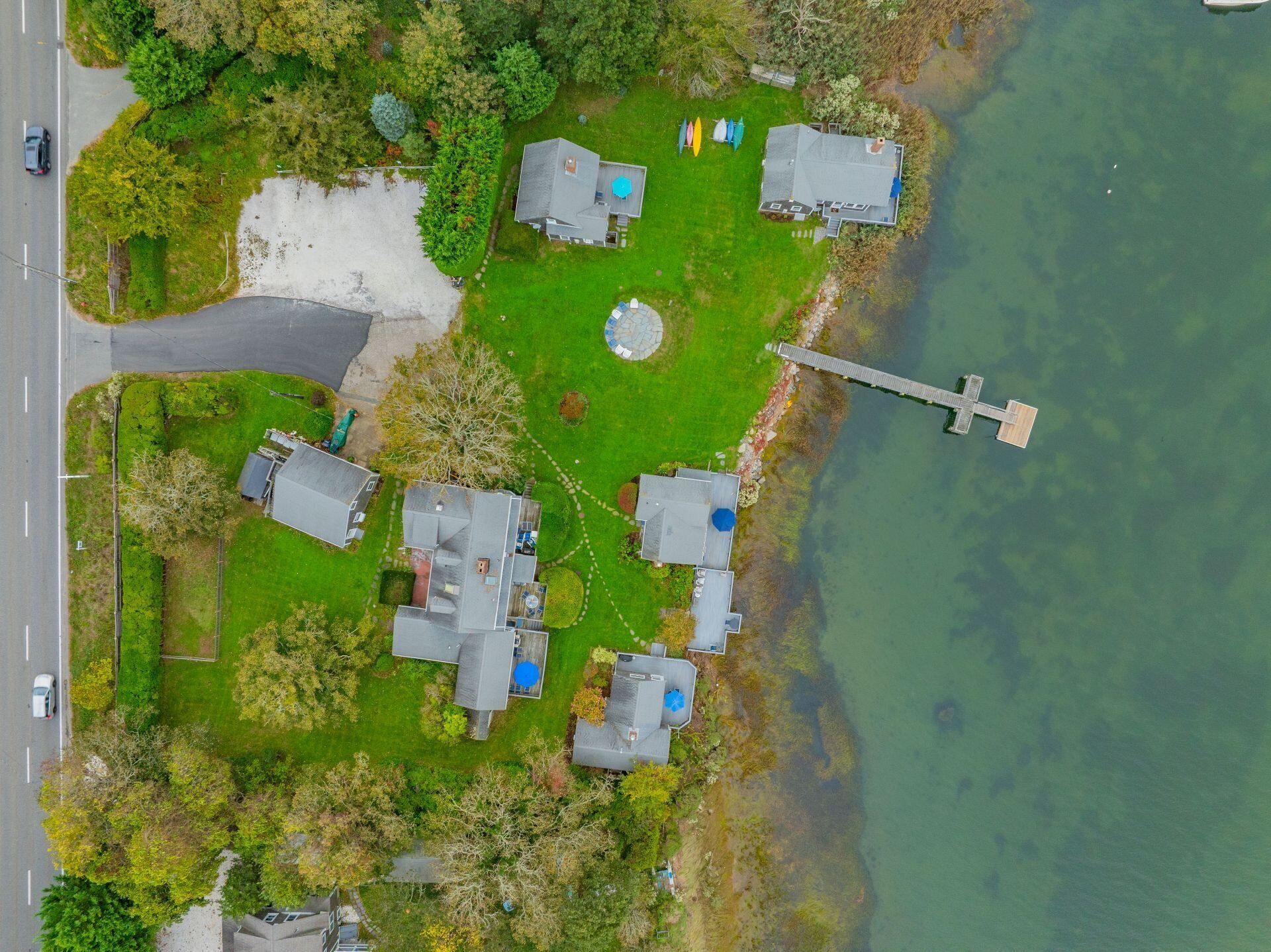 Vista aérea de una propiedad junto al lago, con varias casas, un muelle y una carretera.
