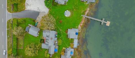 Vista aérea de una propiedad junto al lago, con varias casas, un muelle y una carretera.