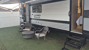 A Coleman RV with a covered patio area featuring outdoor furniture and a small table. - Cozy 1-bedroom studio in adorable Orlando with AC (Orlando)