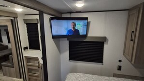 A bedroom with a bed, a television mounted on the wall, and a window with blinds. - Cozy 1-bedroom studio in adorable Orlando with AC (Orlando)