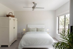 A bedroom with a bed, a ceiling fan, a wardrobe, bedside tables, and a window. - An Unforgettable View (Dixons Creek)