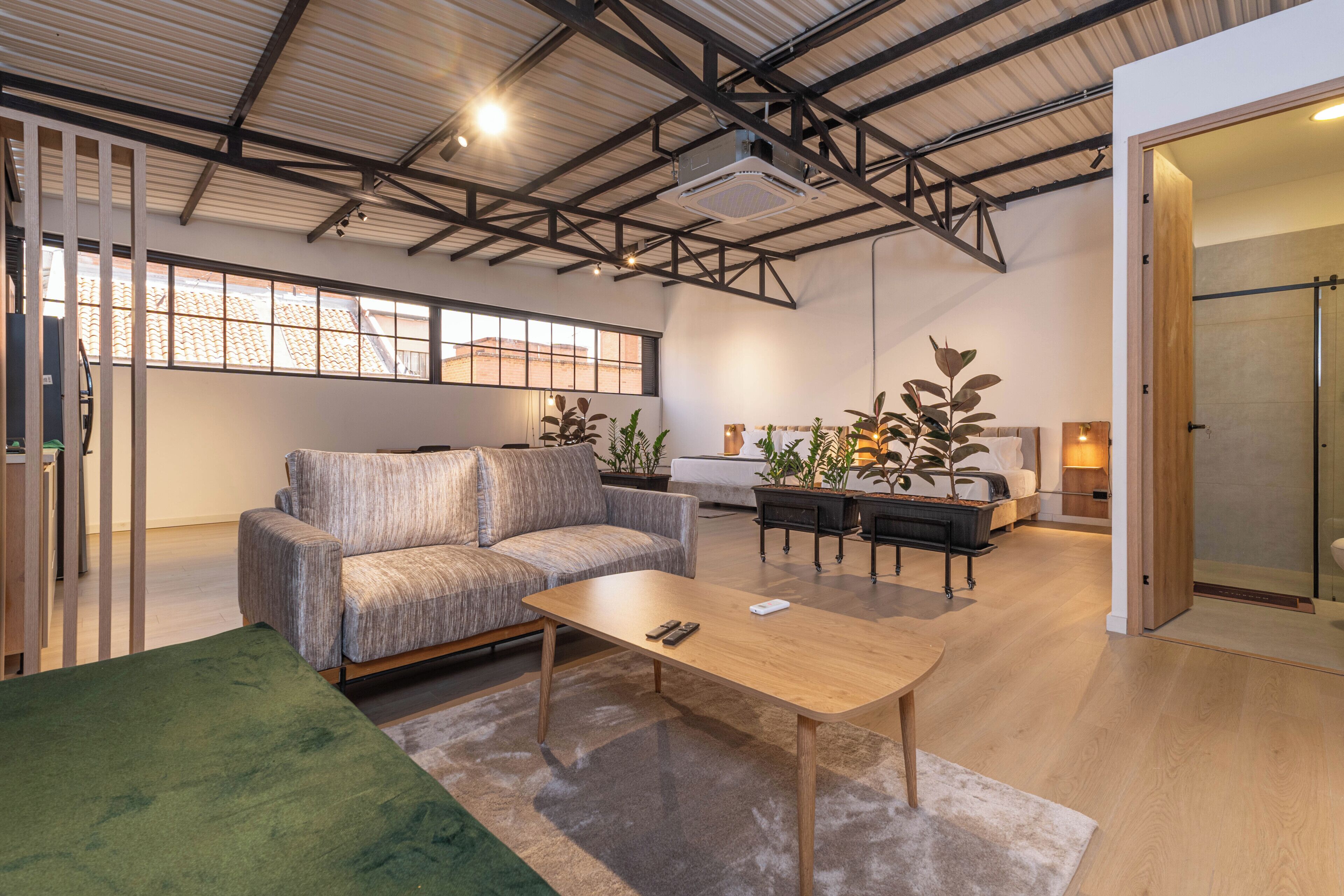 A modern interior with a sofa, coffee table, and potted plants.