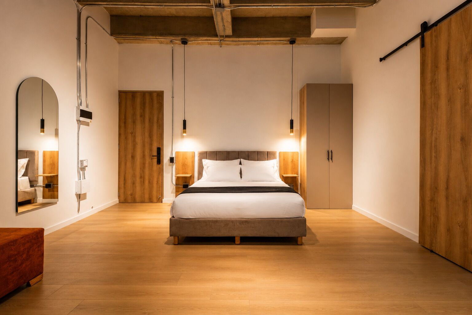 A bedroom with a bed, wooden wardrobe, and a mirror.
