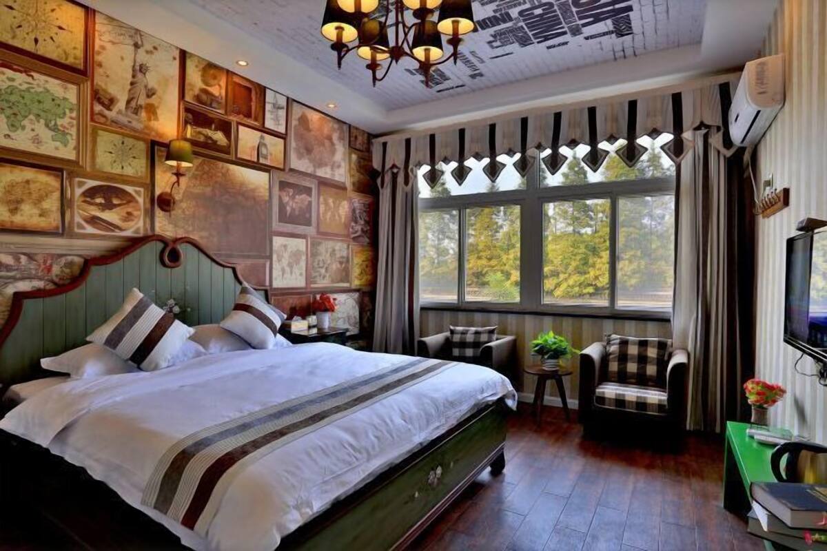 Ein Schlafzimmer mit einem großen Bett, einem Schreibtisch, einem Stuhl und einem Fernseher.