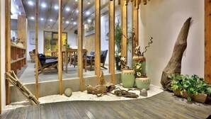 Ein modernes Interieur mit Holzelementen, einer Sitzecke und dekorativen Pflanzen.