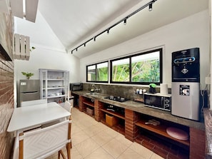 A compact kitchen with a white countertop, a built-in stove, a microwave, and a water dispenser. - Villa White Orchid - Enclosed living area - Seminyak center - Quiet Private Pool (Seminyak)