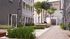 A modern urban courtyard with a paved walkway, benches, and potted plants. - Apartment in the heart of São Paulo (São Paulo)