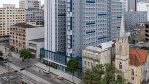 A high-rise hotel with multiple floors, a prominent blue and white facade, and a central courtyard. - Apartment in the heart of São Paulo (São Paulo)