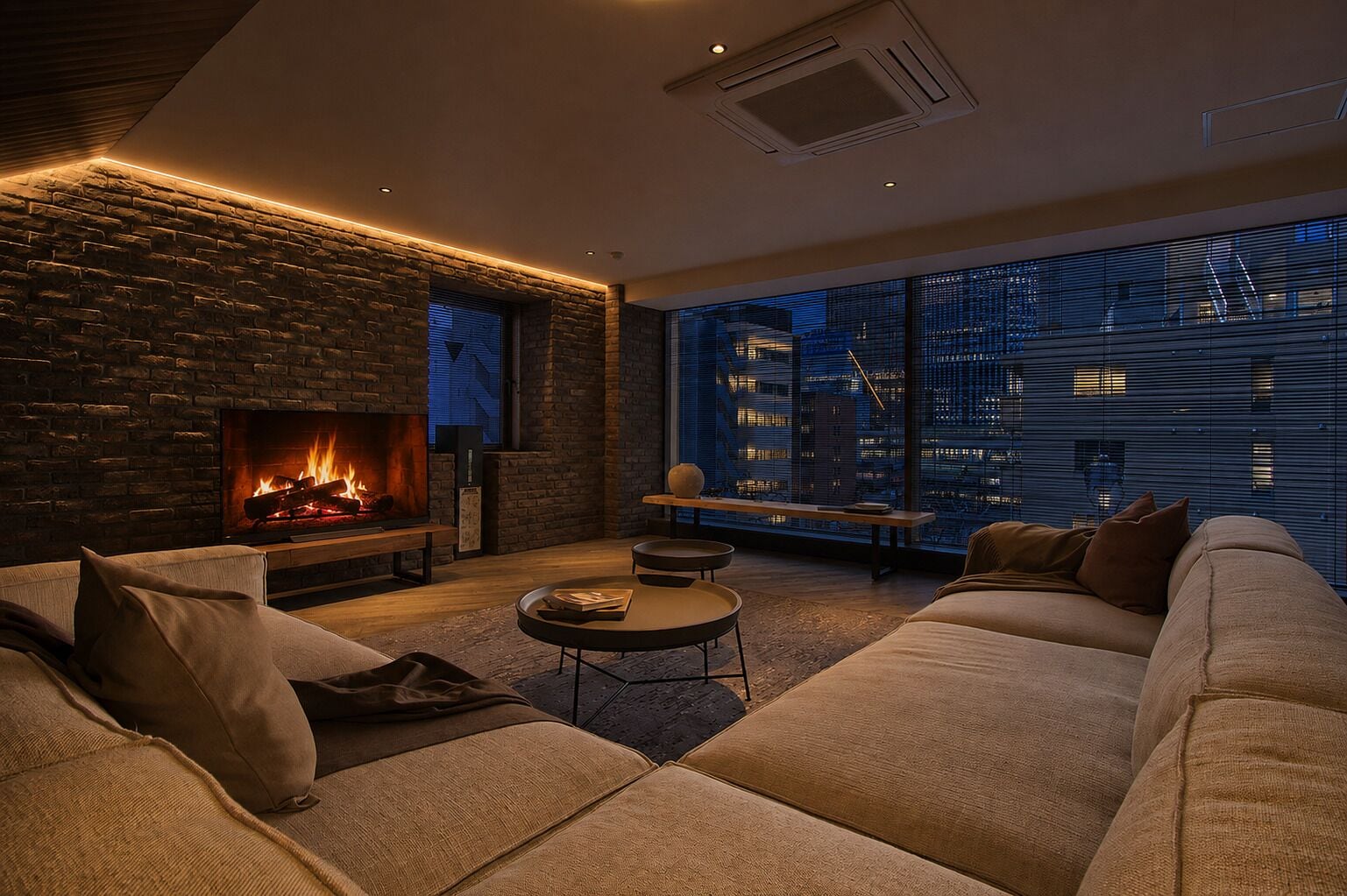 Una sala de estar moderna con chimenea, un juego de sofá, una mesa de centro redonda y vistas de la ciudad de noche.