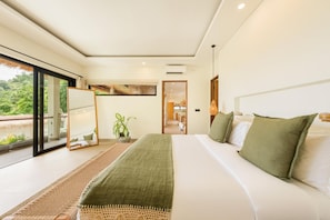 A modern bedroom with a large bed, a mirror, a potted plant, and a view of the outdoors.