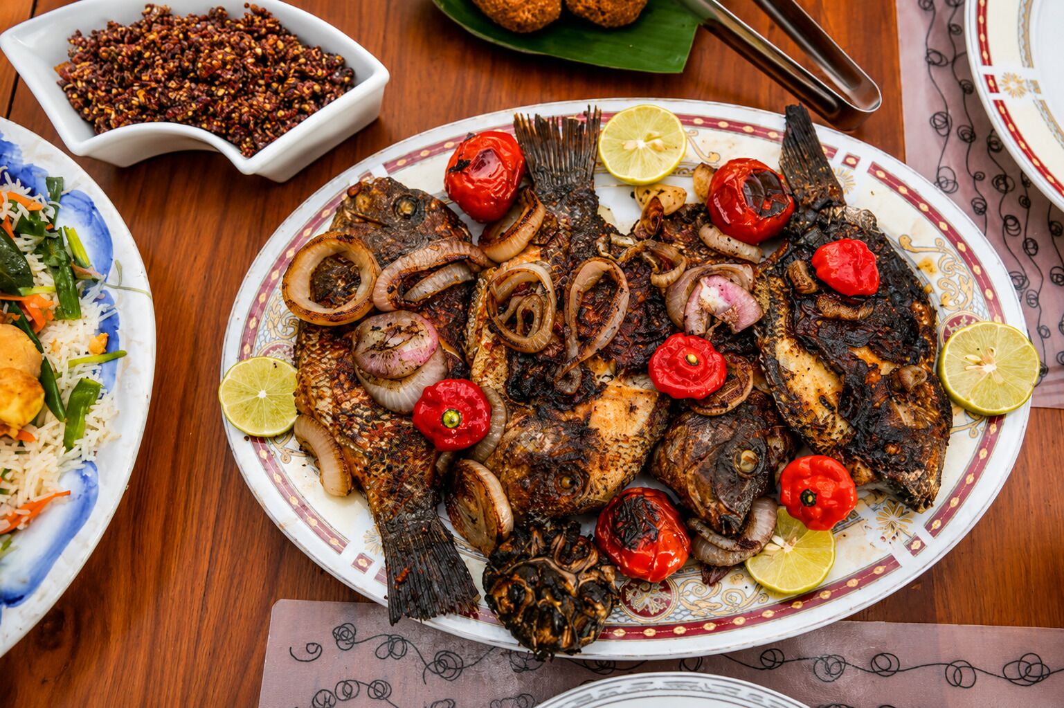 A plate of grilled fish with vegetables and a side of rice.