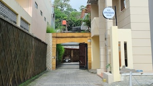Un camino que lleva a un edificio con un letrero que dice "NEW AMANDANI HOUSE".