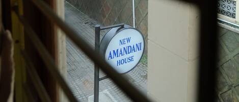 A view through a window with a sign reading "New Amanda House."