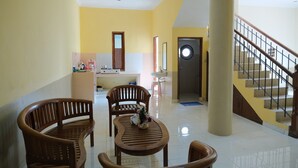Una habitación amplia con un banco de madera, una mesita con un florero y una escalera con barandilla.