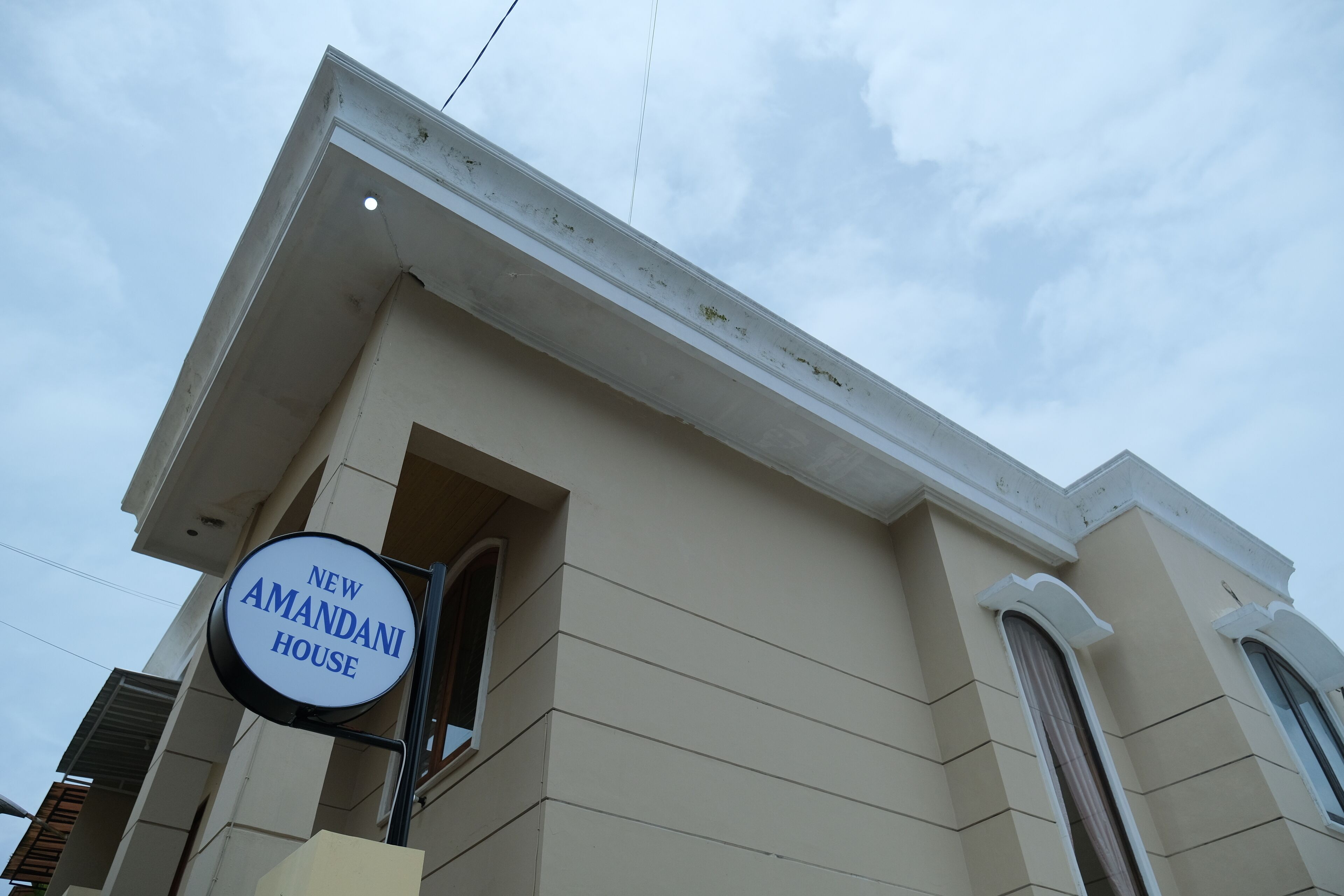 Un bâtiment sur lequel on peut lire l’inscription : « Nouvelle résidence Amandani ».